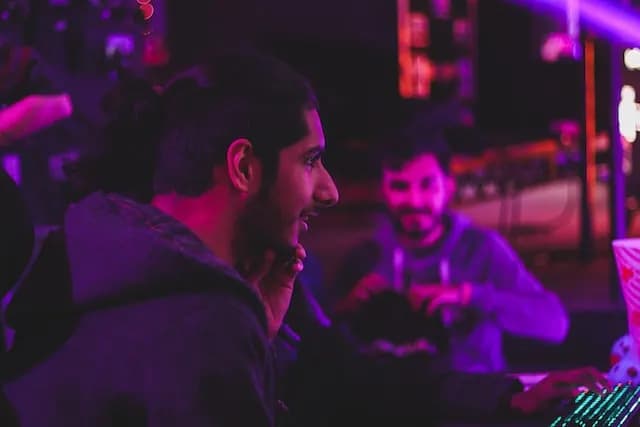 Young man plays computer games with friends